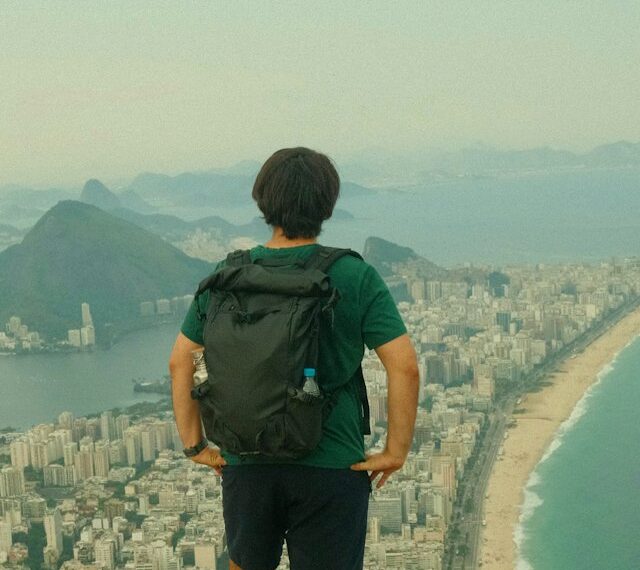 Vivir en el extranjero después de los 30: hombre de pie en un acantilado mirando una ciudad