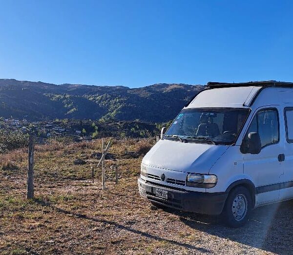 camping para motorhome: casa rodante blanca frente a las sierras al amanecer