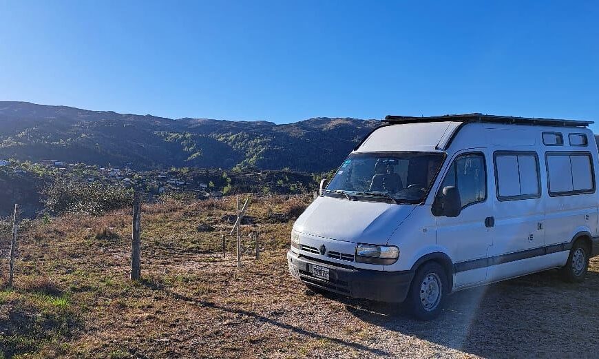 camping para motorhome: casa rodante blanca frente a las sierras al amanecer